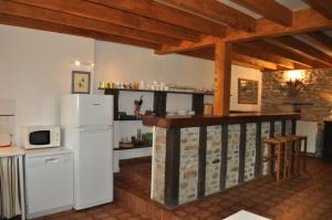 a kitchen with a white refrigerator and a counter at The Coach House - Avec piscine partagée in Osserain-Rivareyte
