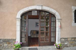 an entrance to a building with a large wooden door at The Coach House - Avec piscine partagée in Osserain-Rivareyte