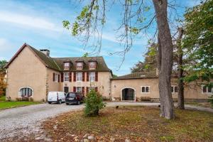 an old house with a car parked in front of it at The Coach House - Avec piscine partagée in Osserain-Rivareyte