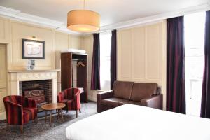 sala de estar con sofá y chimenea en The Castle Hotel Wetherspoon en Ruthin