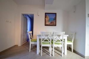 a dining room with a white table and chairs at Apartment &Scaron;ulić in Dubrovnik