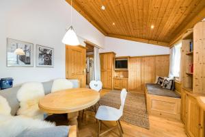 a dining room and living room with a table and chairs at Chalet Steinberg in Leogang