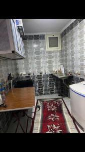 a kitchen with a table and a tiled wall at المعادى. ميدان الجزائر.رقم 3.شقة 6 in Cairo