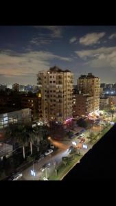 a city at night with cars parked in a parking lot at المعادى. ميدان الجزائر.رقم 3.شقة 6 in Cairo