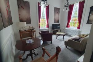 ein Wohnzimmer mit einem Sofa und einem Tisch in der Unterkunft Clairville : Georgian Suite - Central Ross-on-Wye in Ross on Wye