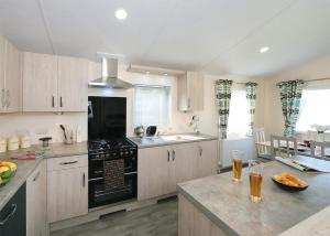 a kitchen with wooden cabinets and a black stove top oven at Springhouse Country Park in Slaley