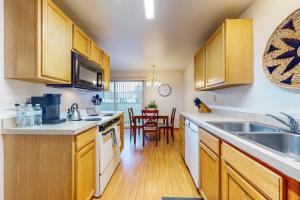 Una cocina con gabinetes de madera y un comedor. en Lofts at Aria 10, en Kalispell