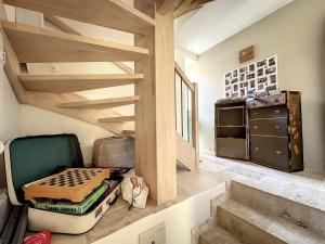 a room with stairs and a room with some luggage at Antre Lacs in Saint-Girod