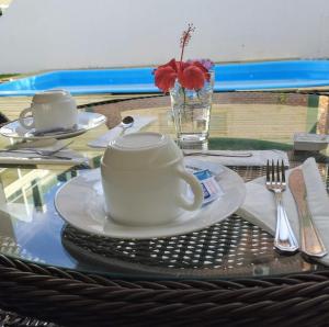 uma mesa com um copo e um prato sobre uma mesa em Pousada Bombinhas House em Bombinhas