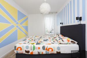 1 dormitorio con 1 cama con sábanas y almohadas coloridas en Appartement Cosy Près de Paris avec vue sur la Tour Eiffel - Parking & Wifi, en Argenteuil