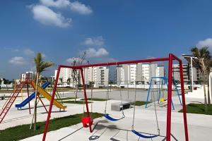 a playground with a swing set in a park at Dream Lagoons Veracruz in Veracruz
