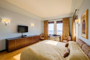 a hotel room with a bed and a television at Villa Sorrentina in Villefranche-sur-Mer