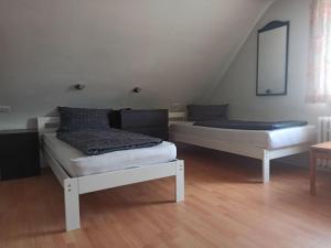 two beds in a room with wooden floors at Monteurzimmer - Waldbronn in Waldbronn