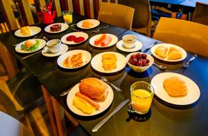 a table with plates of breakfast food on it at Transamerica Fit Sorriso in Sorriso