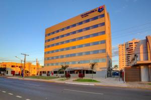 un grand bâtiment orange sur le côté d'une rue dans l'établissement Transamerica Fit Sorriso, à Sorriso