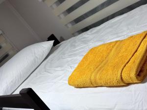 a yellow towel is sitting on a bed at CABAÑAS CAACUPÉ in Castro