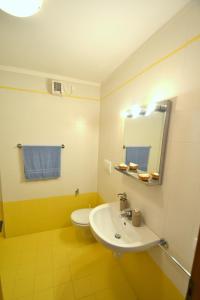 ein Badezimmer mit einem Waschbecken, einem WC und einem Spiegel in der Unterkunft Peaceful apartment on the coast of Bibione in Bibione