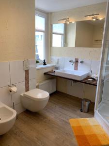 a bathroom with a toilet and a sink at Ferienwohnung Janus Altstadt-Hameln Haus 1 inklusive Parkplatz mit und ohne Balkon in Hameln +18 photos