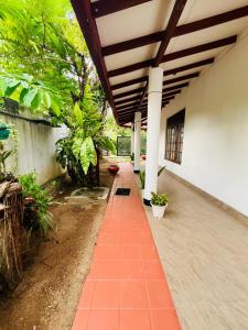 a porch of a house with a brick walkway at Breeze Blows- Solitude Holiday Home in Matara