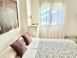 Un dormitorio con una cama con almohadas moradas y una ventana en Hoteltype Penthouse 2 Beds, Parking, WIFI & pool Stunning Views, en Denia