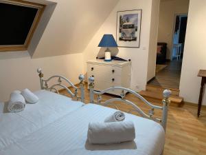 een slaapkamer met een bed met een blauwe lamp op een dressoir bij Vacances de charme entre mer et campagne - Ty Meur in Pleumeur-Bodou