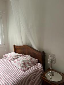 - une chambre avec un lit et une table avec une lampe dans l'établissement Villa damobricero, à Allonnes