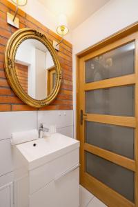 a bathroom with a sink and a mirror at Comfortable Apartment Chramcówki in the Centre of Zakopane by Renters in Zakopane