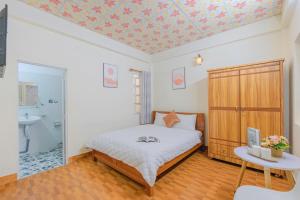 a bedroom with a bed and a bathroom at Mie House Da Lat in Xuan An