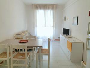 eine Küche und ein Esszimmer mit einem Tisch und einem TV in der Unterkunft Lovely flat in Bibione Pineda 100m from the beach in Bibione