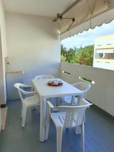 einen weißen Tisch und Stühle in einem Zimmer mit Fenster in der Unterkunft Lovely flat in Bibione Pineda 100m from the beach in Bibione
