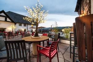 a patio with a table and chairs and a tree at The Castle Hotel Wetherspoon in Ruthin