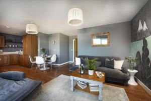 a living room with a couch and a table at Bathsheba, Ocean 1 in Newquay