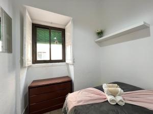 a bedroom with a bed with a dresser and a window at Ile Aina Exterior Nuevo Peña in Madrid