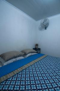 1 dormitorio con 1 cama y ventilador en la pared en Monteverde River House, en Monteverde