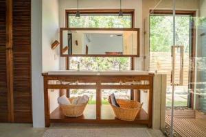 ein Badezimmer mit zwei Körben und einem Spiegel in der Unterkunft Cheerful 2 bedroom Villa with Pool in Benque Viejo del Carmen