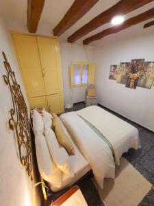 1 dormitorio con 1 cama con sábanas y almohadas blancas en Casa de Danann, en Rasquera