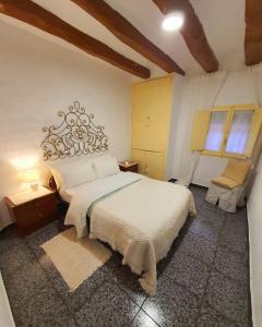 1 dormitorio con 1 cama grande y 2 ventanas en Casa de Danann, en Rasquera