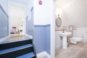 baño con lavabo y aseo y escalera en SKYR Guest House, en Hveragerði