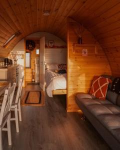 Timber Valley Pods في Galston: غرفة مع سرير وأريكة في منزل صغير