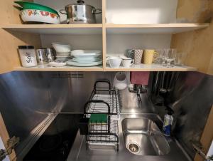 - un évier de cuisine avec des assiettes et de la vaisselle sur les étagères dans l'établissement Casa Campo de' Fiori, à Rome