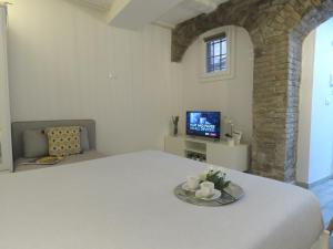 a white room with a bed and a tv at Oberdan Apartment in Bologna