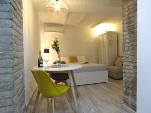 a room with a bed and a table and a green chair at Oberdan Apartment in Bologna