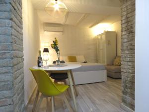 ボローニャにあるOberdan Apartmentのベッド、テーブル、緑の椅子が備わる客室です。