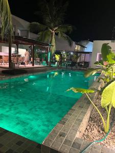 a swimming pool in a resort at night at Pousada Maré do Francês in Praia do Frances