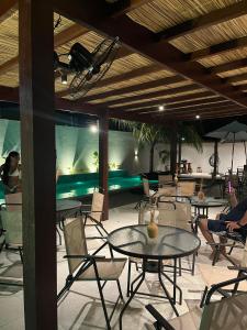 une terrasse avec des tables et des chaises ainsi qu'une piscine dans l'établissement Pousada Maré do Francês, à Praia do Frances