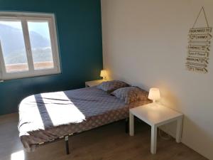 ein kleines Schlafzimmer mit einem Bett und einem Fenster in der Unterkunft Gîte Ludomi in Vercheny