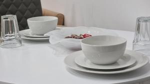 a white table with three cups and plates on it at Brand New Flat Close To Turnpike Lane Tube Station in London