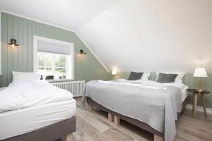 2 camas en una habitación con paredes verdes y blancas en SKYR Guest House en Hveragerði