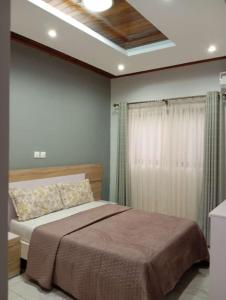 1 dormitorio con cama y techo en Chambre de luxe chez FOUR IN ONE Résidence, en Limbe