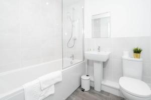 Baño blanco con aseo y lavamanos en Luxury Selly Oak Apartment near QE & Uni - Secure Parking - 20CC, en Birmingham